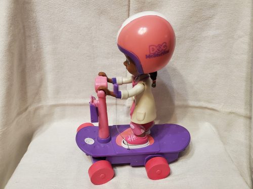 Doc McStuffins (Dr. Plüssi) baba rollerrel – használt, jó állapotban (23 cm) (d2)