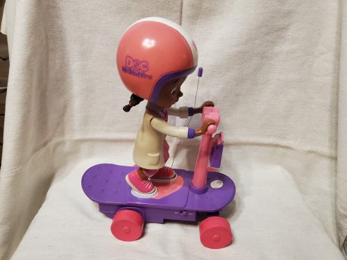 Doc McStuffins (Dr. Plüssi) baba rollerrel – használt, jó állapotban (23 cm) (d2)