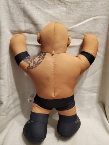 WWE The Rock pankrátor plüssfigura – használt, bolyhos, foltos állapotban (A4)